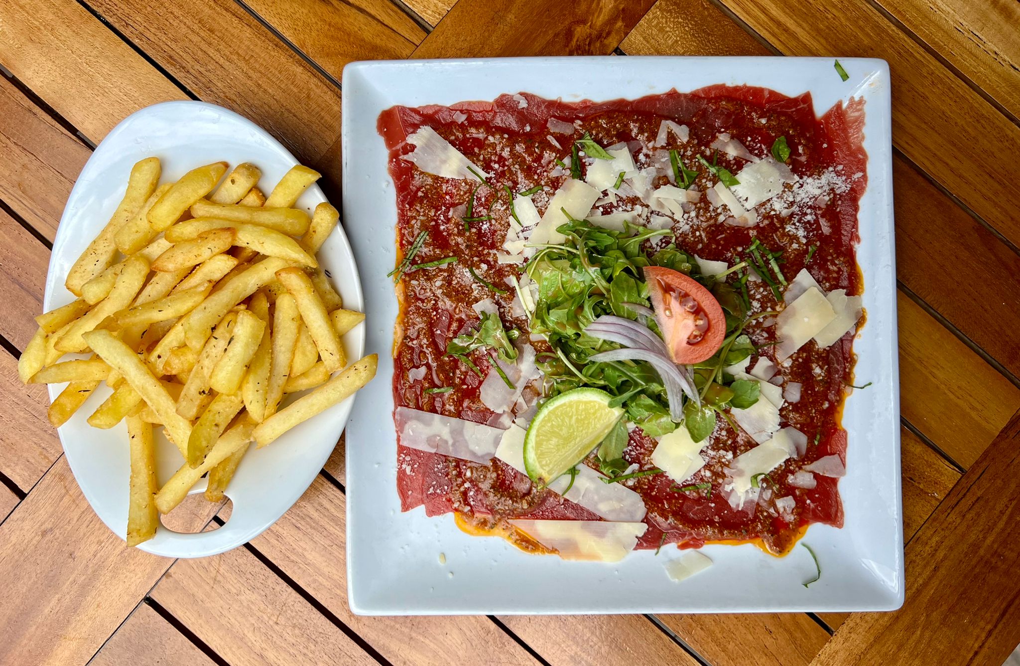 Beef carpaccio with red pesto served with fries and salad